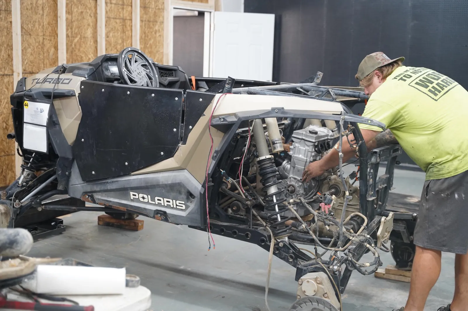 Technician working on the exposed engine of a Polaris UTV in the Casslake workshop